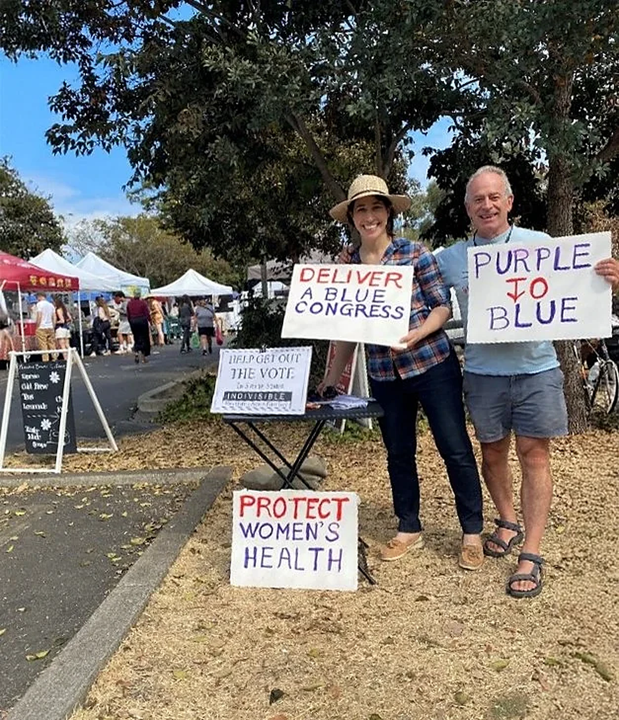RAEB volunteers holding Purple to Blue and Deliver a Blue Congress signs